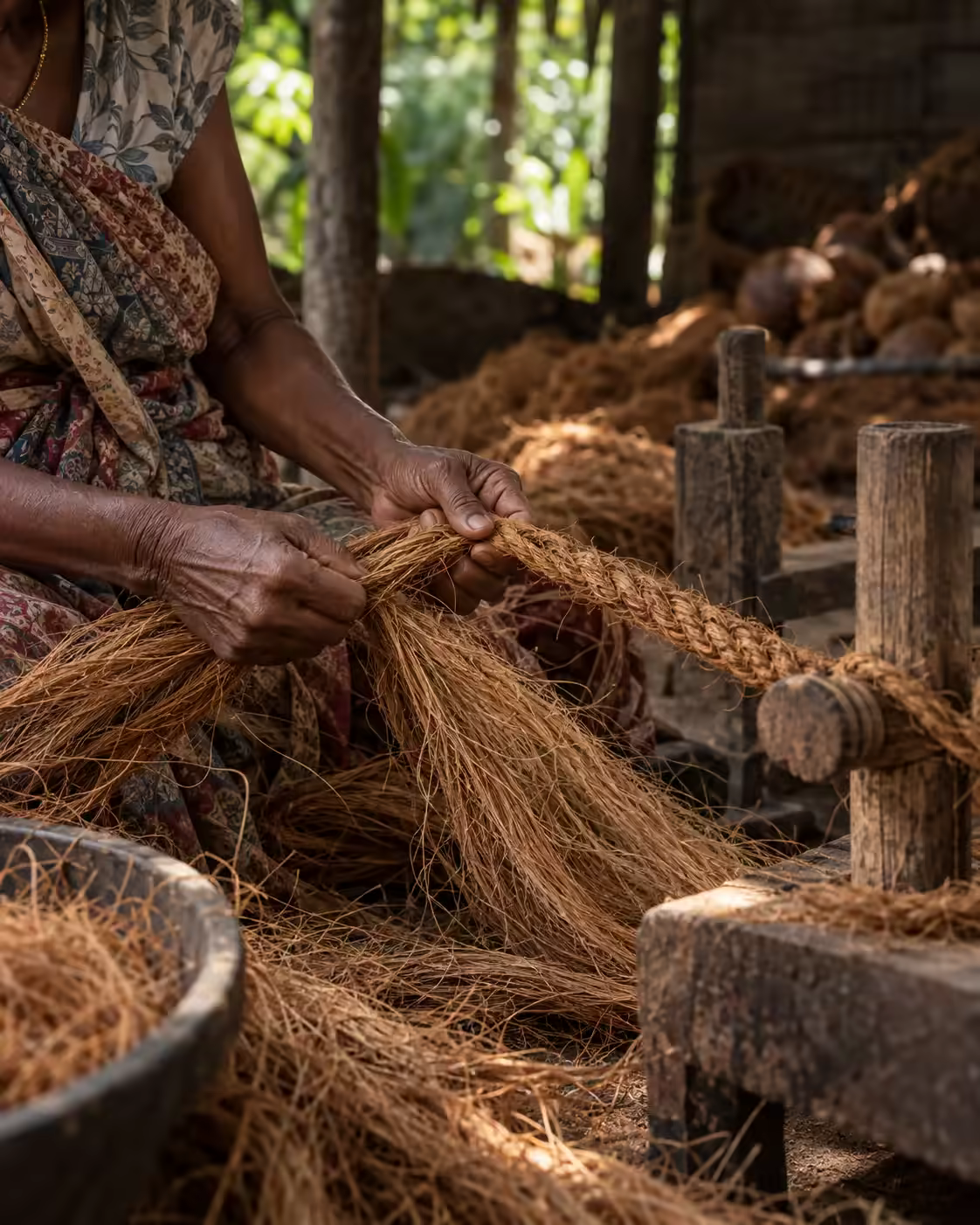 Hands twisting Sri Lankan coconut fibre into coir rope